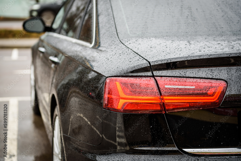 Car tail light. Detail black metallic car with rear light close up ...