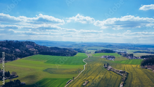 Bird's eye view of abstraction agricultural area and green wavy fields in sunny day. Aerial photography, top view drone shot. Ukrainian agrarian region, Europe. Picturesque wallpaper. Beauty of earth. © Pavel