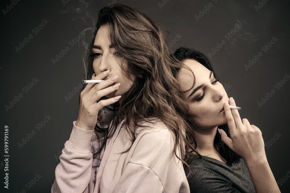 Foto de Two sexy woman smoking cigarette. Sensual women. LGBT lesbian