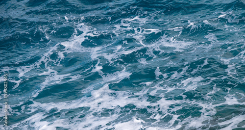Ocean water background. Blue sea texture with waves and foam
