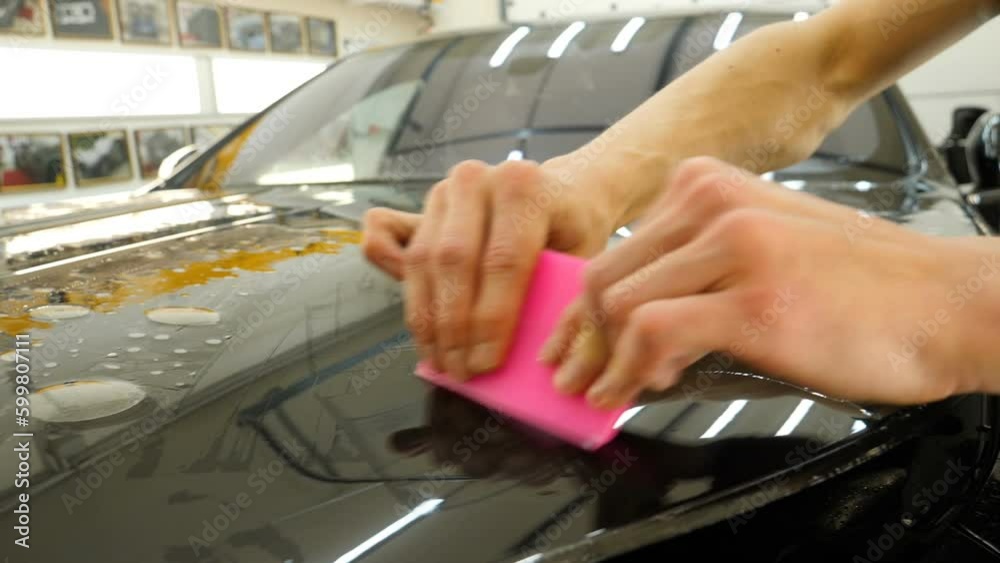 Close up to PPF installation process on a front headlight and hood. PPF ...