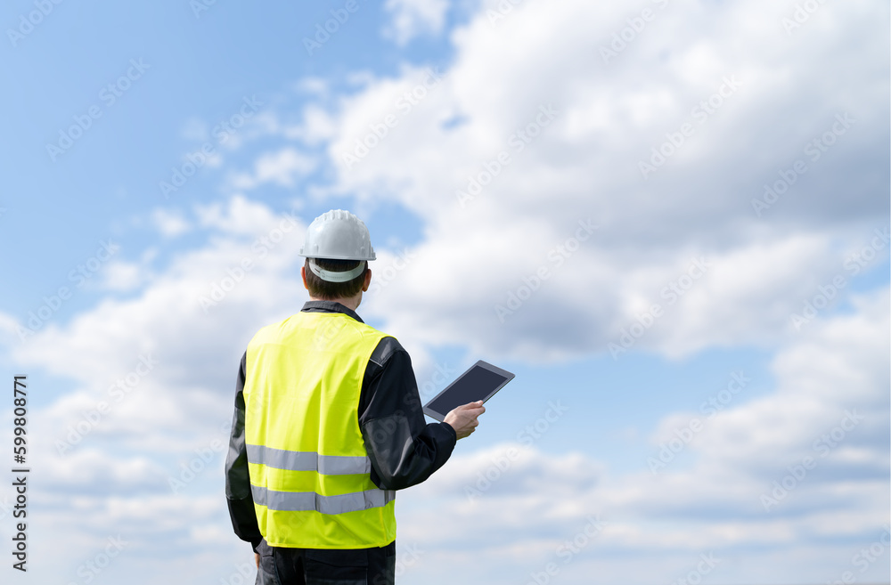 Engineer with digital tablet on a background of blue sky Engineer with digital tablet on a background of blue sky