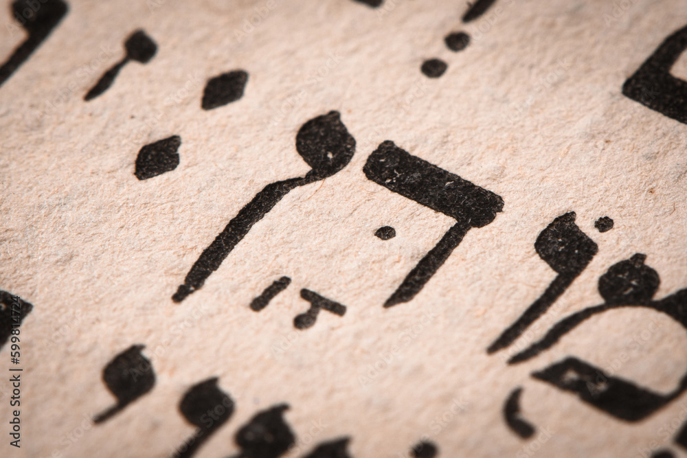 Hebrew word in Torah page. English translation is name Dan, the founder of the Israelite Tribe of Dan. First of the two sons of Jacob and Bilhah. Selective focus. Closeup.