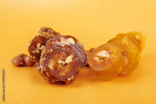 churchkhela, Traditional Georgian candy from nuts and grape juice on an orange background, copy space