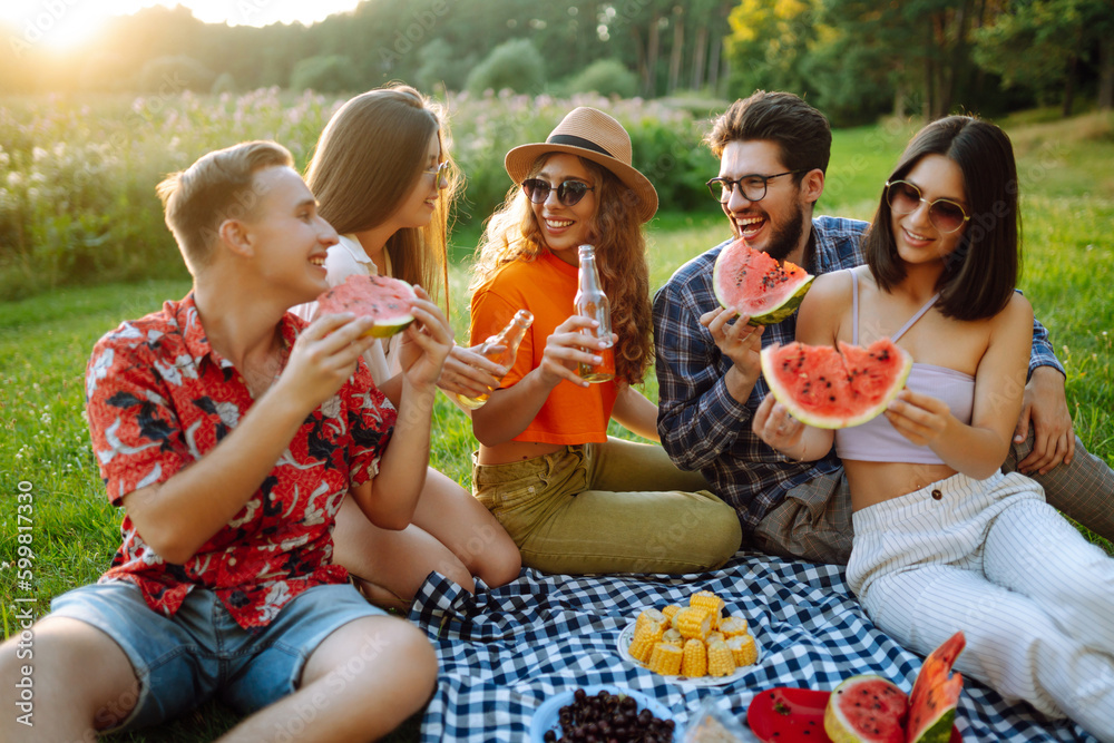 Happy groop of friend resting in nature in the picnic drinking beer, cheers. People, lifestyle, relaxation and vacations concept. Happy groop of friend resting in nature in the picnic drinking beer, cheers. People, lifestyle, relaxation and vacations concept.