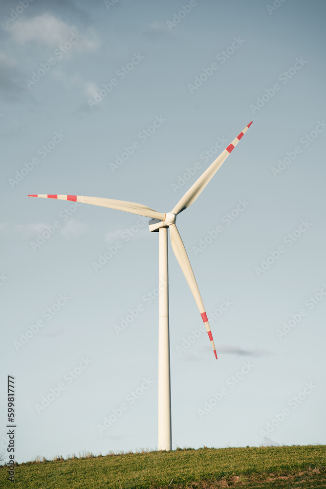 One turbine mill. Wind turbine in the green field against blue sky with fluffy clouds. Concept of green energy and sustainable future. One turbine mill. Wind turbine in the green field against blue sky with fluffy clouds. Concept of green energy and sustainable future.