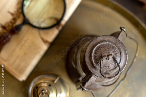 Abstract image of the lamp, magnifying glass and newspaper on the table in retro style. View from the top.