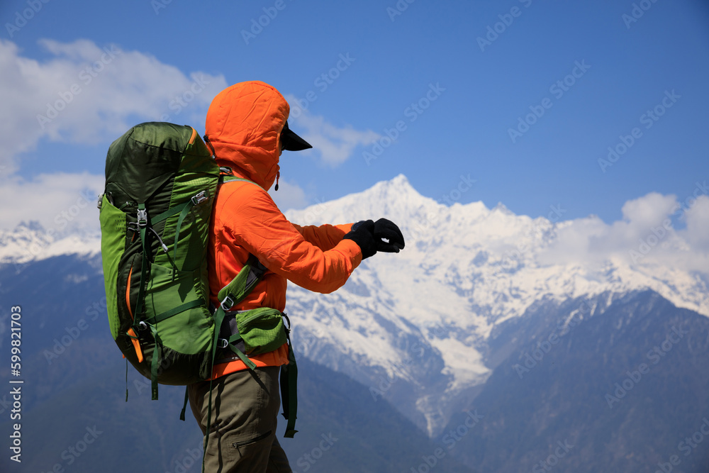 Woman backpacker set the smartwatch on high altitude mountains Woman backpacker set the smartwatch on high altitude mountains
