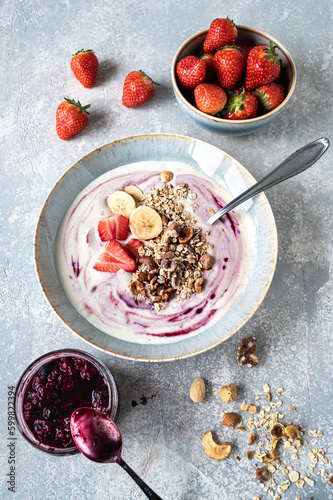 Smoothie mit Joghurt, Bananen, Erdbeeren, Blaubeeren und gerösteten Haferflocken und Nüssen.    