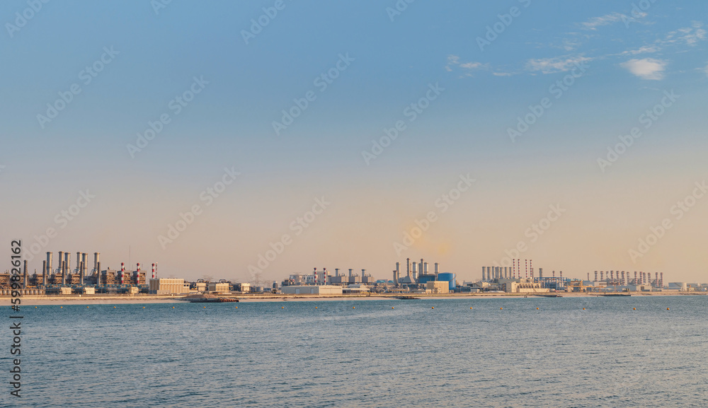 Air pollution from power plant chimneys. view from Bluewater island in Dubai city. Urban landscape smoked polluted atmosphere from emissions of plants and factories, view of pipes with color smoke