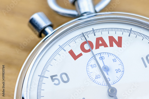 Loan obligation and repayment, financial concept : Closeup of a stopwatch with the word LOAN. Depicting timely loan repayment to reduce interest accrued, maintain good credit score and credit history. photo