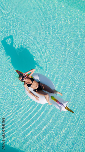 Top view of beautiful woman relaxing in swimming pool