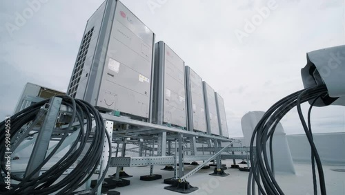 KYIV, UKRAINE - APRIL 2023: The air conditioning and ventilation system of a large industrial facility is located on the roof. It includes an air conditioner, smoke exhaust, and ventilation. photo