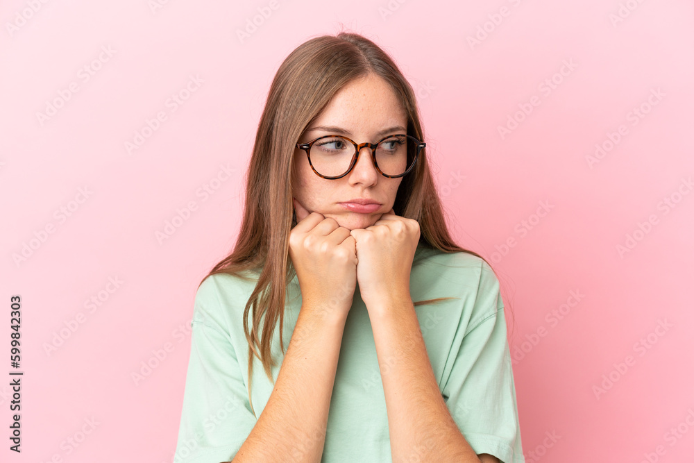 Young Lithuanian woman isolated on pink background With glasses and tired Young Lithuanian woman isolated on pink background With glasses and tired