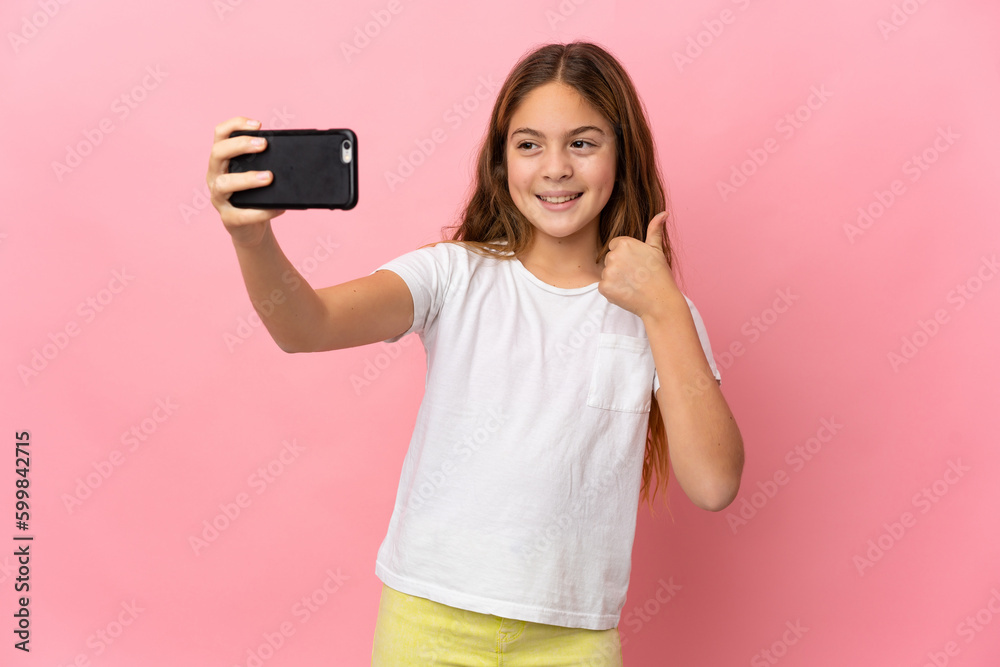 Child over isolated pink background making a selfie with mobile phone Child over isolated pink background making a selfie with mobile phone