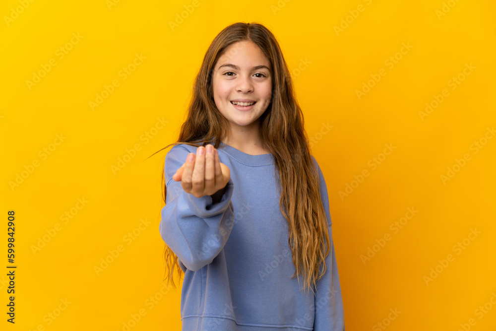 Child over isolated yellow background inviting to come with hand. Happy that you came Child over isolated yellow background inviting to come with hand. Happy that you came