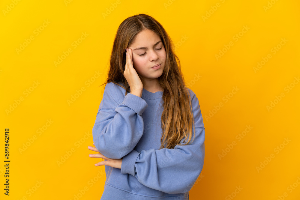 Child over isolated yellow background with headache Child over isolated yellow background with headache