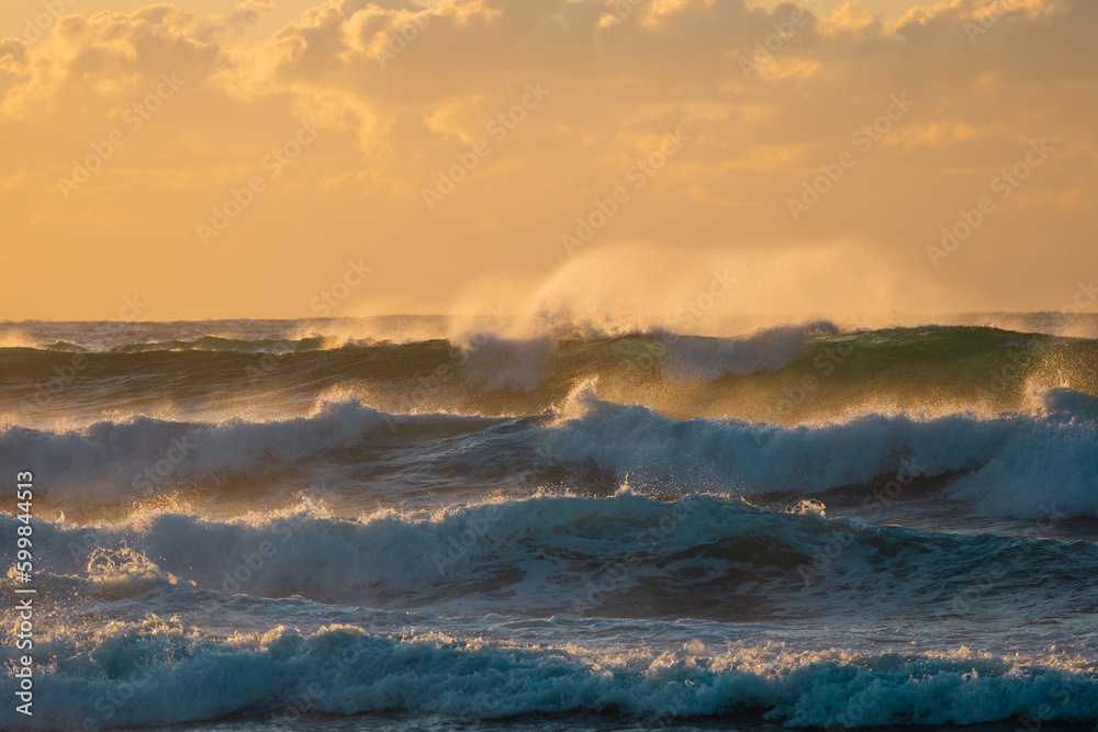 Layers of wave with sunrise golden light.