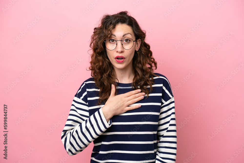 Young caucasian woman isolated on pink background surprised and shocked while looking right