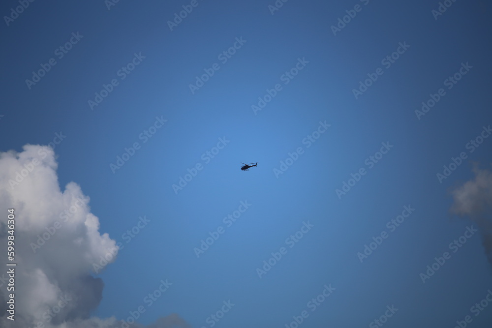 helicopter isolated in blue expansive sky helicopter isolated in blue expansive sky