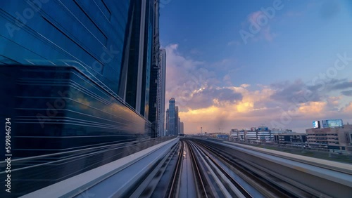 Time lapse Hyper lapse high speed Dubai Metro travel along sheikh Zayed road passing high rise building in downtown during beautiful sunrise