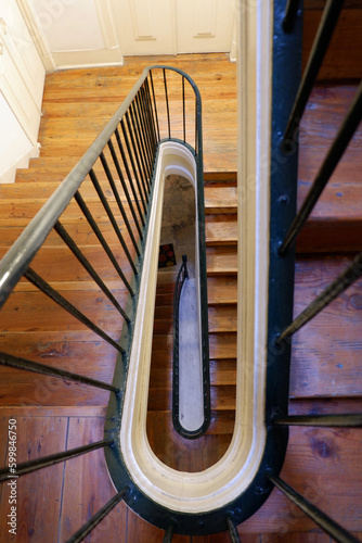 Antique wooden staircase in Lisbon, Portugal. Old vintage architecture details. High angle aerial view from above to down. Vertical photo