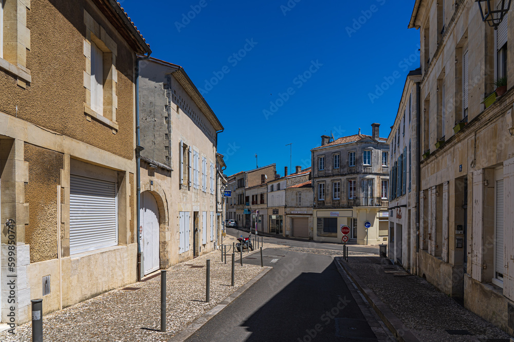 A narrow street between houses in a small French town