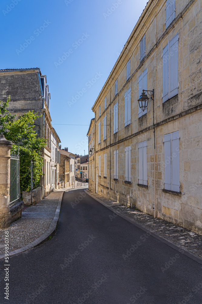 a narrow street with sidewalks in a small french town