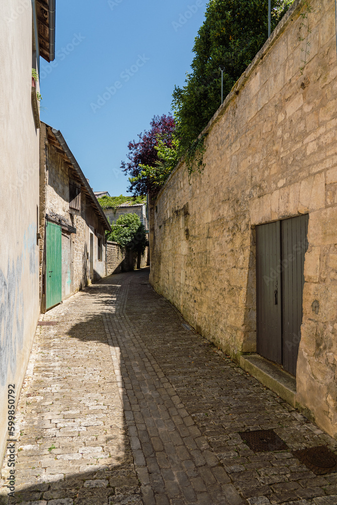 A very narrow street in a small French town between the walls of houses
