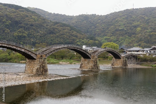 Kintaikyo Bridge in a Rainy Atmosphere: A Damp Impression with Drizzle, Silhouette Faintly Reflected on the River Surface