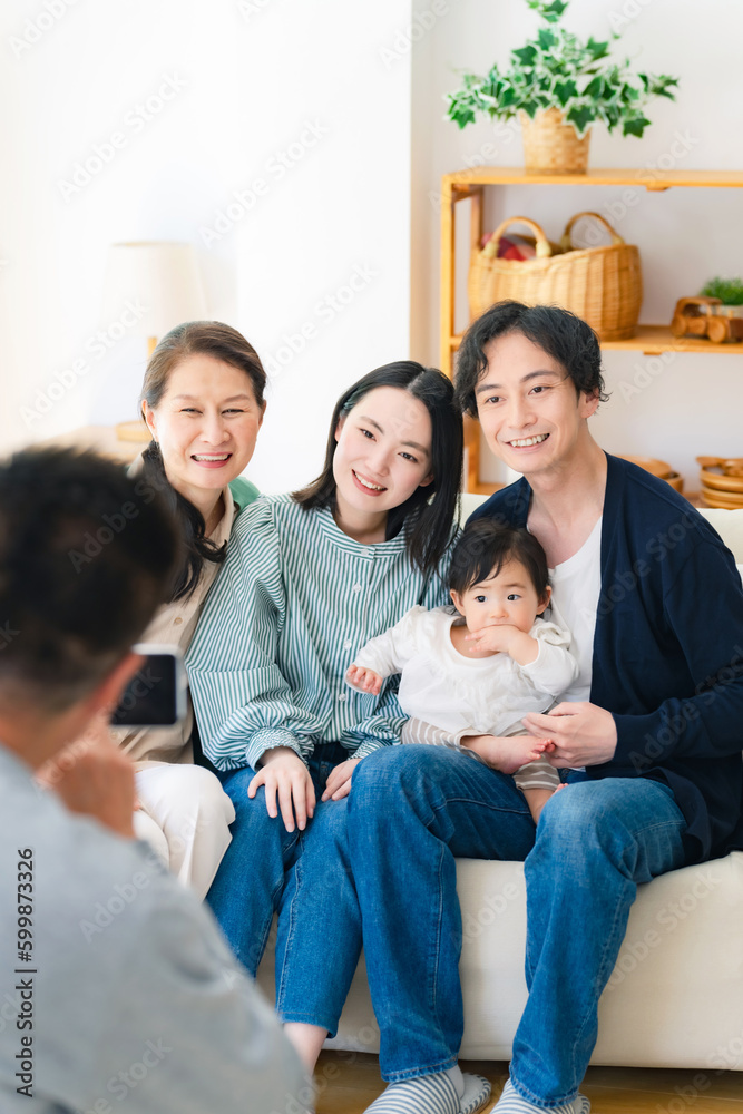 赤ちゃんと家族をスマホで撮影するおじいちゃん 赤ちゃんと家族をスマホで撮影するおじいちゃん