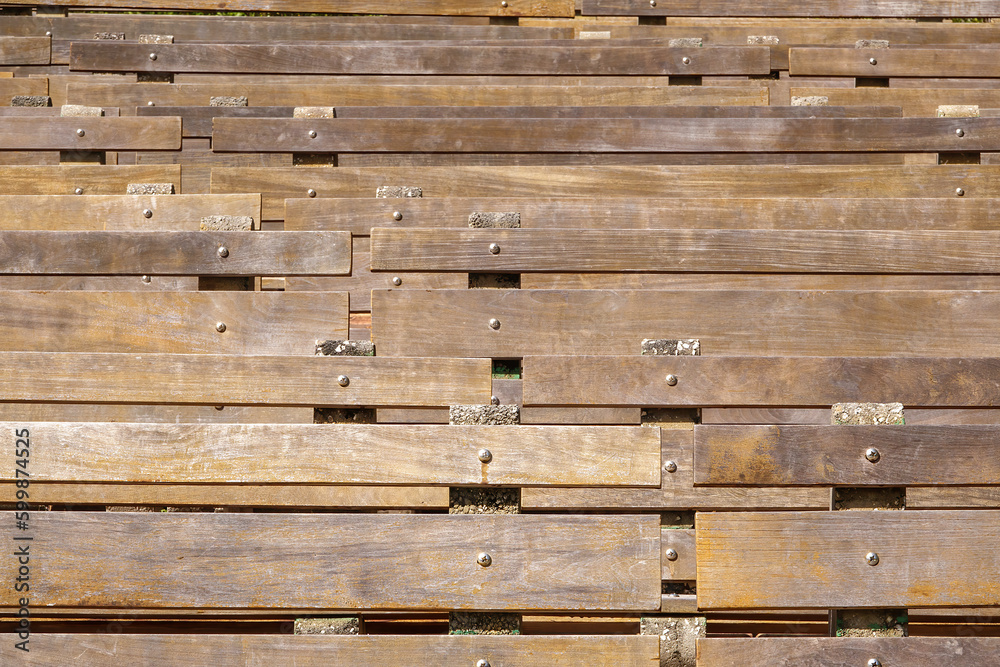 Frontal view of permanent wooden benches, affixed to conglomerate spacers or stabilizers, in an outdoor amphitheater in a botanical park in central Florida, for motifs of events, public gatherings Frontal view of permanent wooden benches, affixed to conglomerate spacers or stabilizers, in an outdoor amphitheater in a botanical park in central Florida, for motifs of events, public gatherings