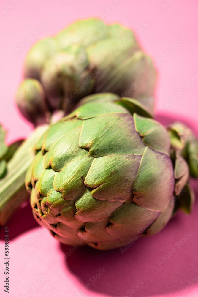 Fototapeta premium Fresh green artichokes isolated on pink background