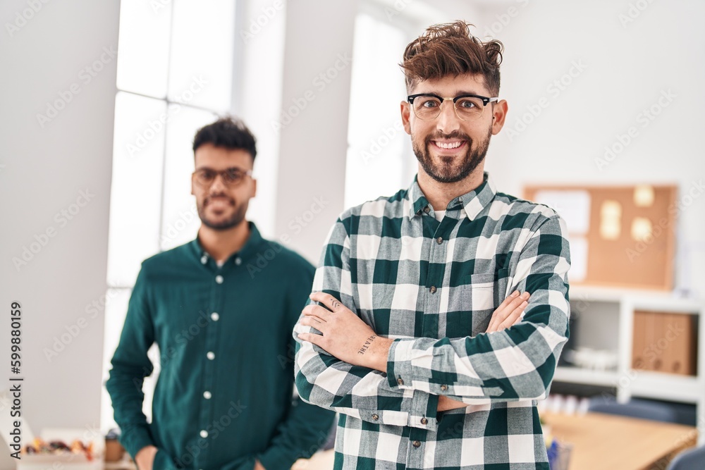 Fototapeta premium Young couple business workers standing with arms crossed gesture at office