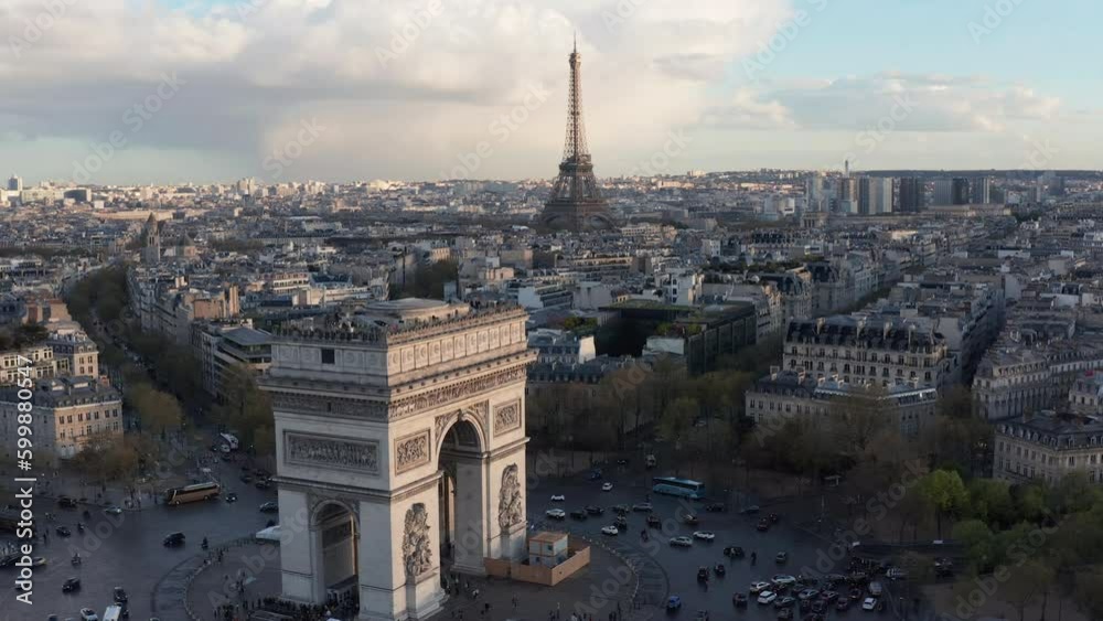 Aerial above Arc de Triumph in foreground and Eifel Tower in background, Paris. Late afternoon light, historical building rooftops Aerial above Arc de Triumph in foreground and Eifel Tower in background, Paris. Late afternoon light, historical building rooftops