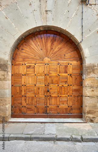 Billede på lærred entrance with a semicircular arch with a wooden door in a grid with wooden slats
