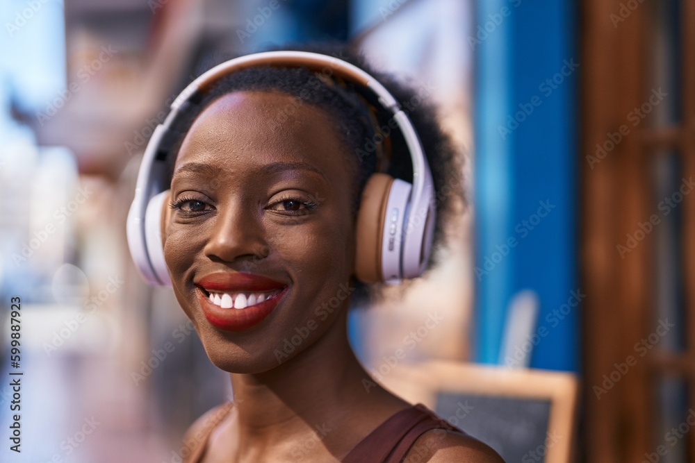 African american woman smiling confident listening to music at street