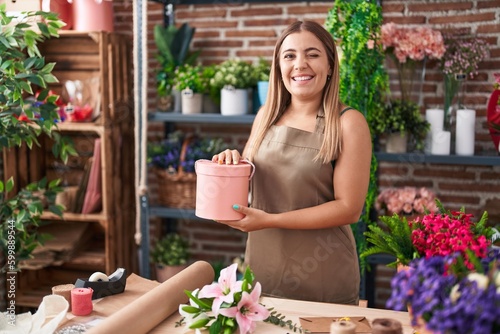 Young blonde woman working at florist shop winking looking at the camera with sexy expression, cheerful and happy face.