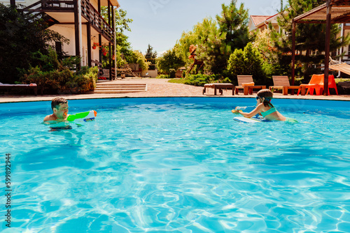 Father and daughter have fun with water guns in the pool.