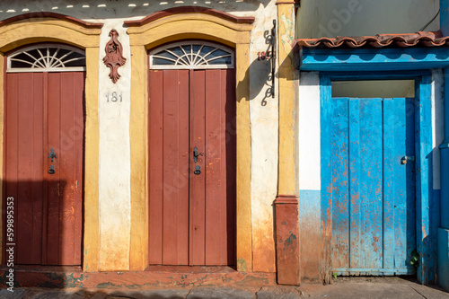 Beautiful colorful old mansions in the historic city of Sabará. Brazil. Blue sky. Stone-paved street. Horizontal.