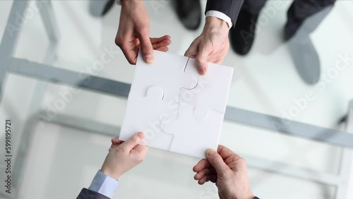 Business teamwork with white puzzle of four pieces cooperation unity concept