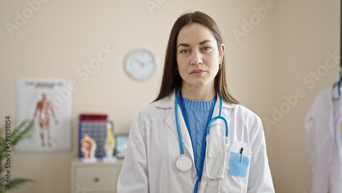 Young caucasian woman doctor standing with serious expression at clinic