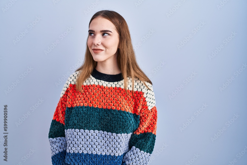 Young hispanic girl standing over blue background smiling looking to the side and staring away thinking. Young hispanic girl standing over blue background smiling looking to the side and staring away thinking.