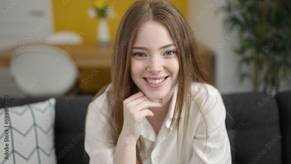 Young blonde woman smiling confident sitting on sofa at home Young blonde woman smiling confident sitting on sofa at home