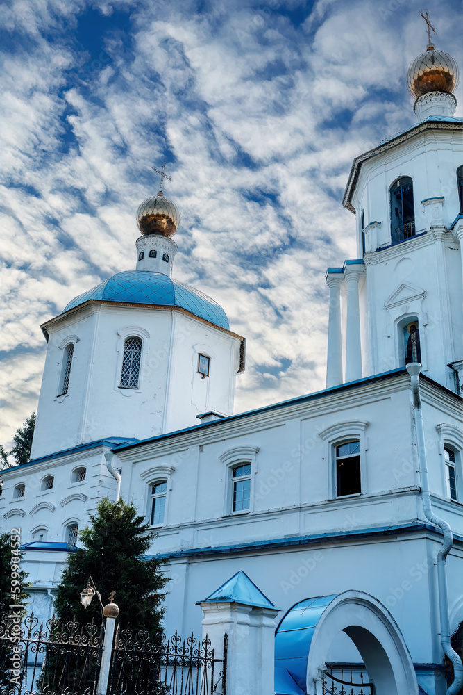 Orthodox Spassky church in Solnechnogorsk. Gilded domes against the background of cloudy blue sky.