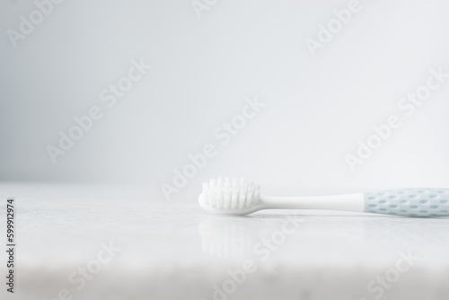 Pastel blue toothbrush with white bristles on a white background  Pastel blue toothbrush with copy space