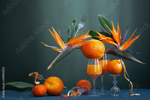 exotic still life with bird of paradise flowers, orange juice and orange fruits photo