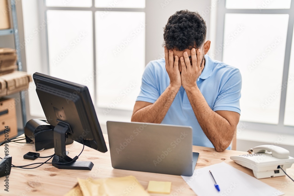 Young hispanic man ecommerce business worker stressed working at office