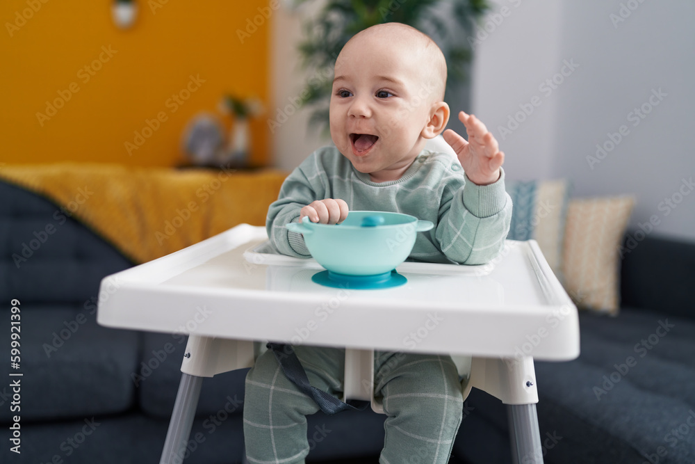 Adorable caucasian baby smiling confident sitting on highchair at home Adorable caucasian baby smiling confident sitting on highchair at home