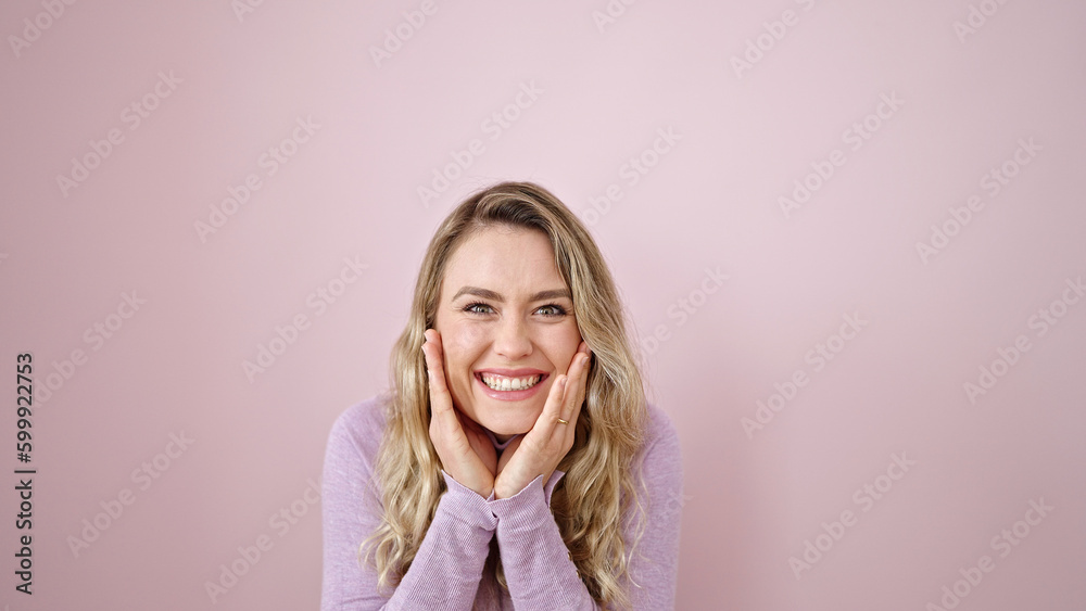 Young blonde woman standing with surprise expression over isolated pink background Young blonde woman standing with surprise expression over isolated pink background